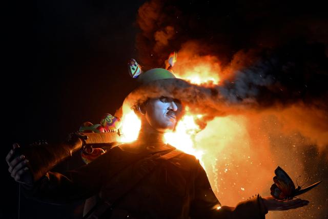 A 'ninot' (cardboard figurine whose name literally means 'doll' in Valencian language) depicting Charles Chaplin, burns during the "Nit de la Crema" (the night of the burning) on the last night of the Fallas Festival in Valencia on March 19, 2026. The 'fallas' —gigantic cardboard structures depicting current events and celebrities, with individual figures known as 'ninots'— are burned in the streets of Valencia on March 19 as a tribute to Saint Joseph, the patron saint of the carpenters' guild." (Photo by Jose JORDAN / AFP)