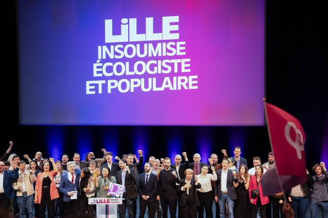 Founder of French left-wing party La France Insoumise (LFI) Jean-Luc Melenchon (4th-L) and French leftist party La France Insoumise (LFI) candidate for mayor of Lille, Lahouaria Addouche (5th-L) sing with others LFI members at the end of a campaign meeting, in Lille, northern France, on March 19, 2026, ahead of the second round of France's 2026 municipal elections. French voters are scheduled to head to the polls for the second round of municipal elections on March 22, 2026. (Photo by Elise HOUBEN / AFP)