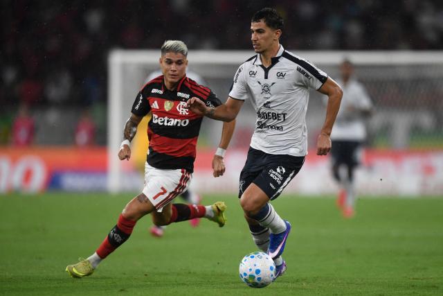 Flamengo's forward #07 Luiz Araujo and Remo's forward #15 Vitor Bueno fight for the ball during the Brasileirao Serie A football match between Flamengo and Remo at the Maracana Stadium in Rio de Janeiro, Brazil, on March 19, 2026. (Photo by Daniel RAMALHO / AFP)