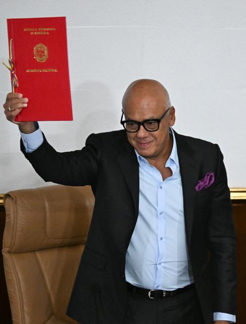 Venezuela's National Assembly president Jorge Rodriguez shows the decree recognizing the Venezuelan Baseball Federation after the national baseball team victory in the World Baseball Classic at the National Assembly in Caracas on March 19, 2026. (Photo by Juan BARRETO / AFP)