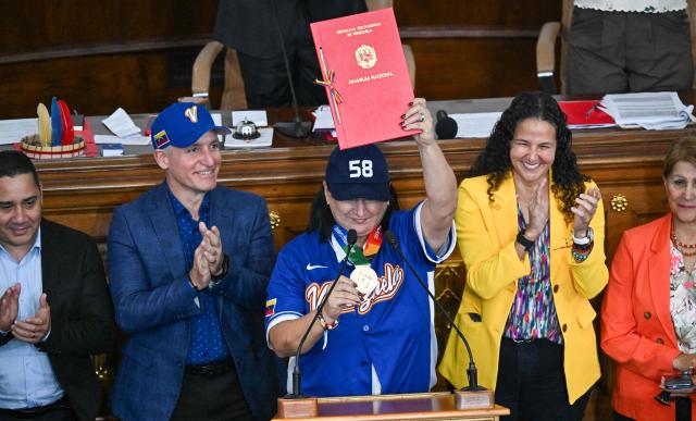 Aracelis Leon (C), president of the Venezuelan Baseball Federation (FVB), receives the decree recognizing the FVB following the national baseball team's victory in the World Baseball Classic at the National Assembly in Caracas on March 19, 2026. (Photo by Juan BARRETO / AFP)
