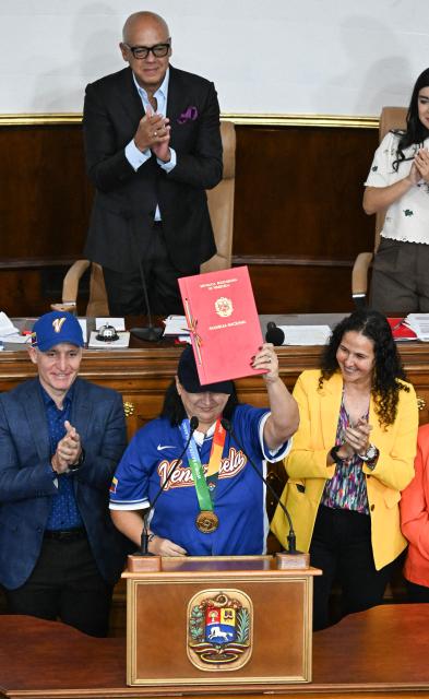Aracelis Leon (C), president of the Venezuelan Baseball Federation (FVB), receives the decree recognizing the FVB following the national baseball team's victory in the World Baseball Classic at the National Assembly in Caracas on March 19, 2026. (Photo by Juan BARRETO / AFP)