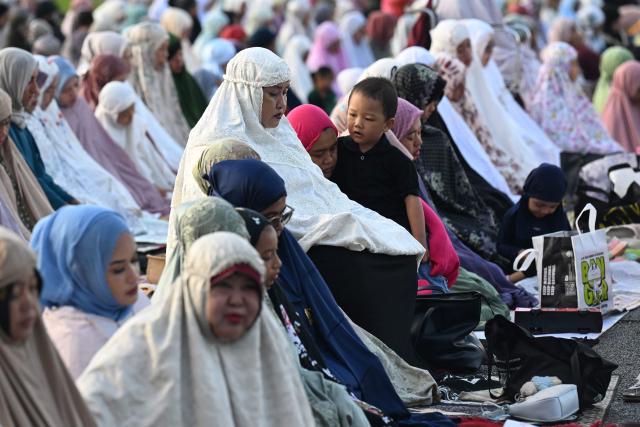Muslim devotees offer Eid al-Fitr prayer at Bali's Bajra Sandhi monument and park in Denpasar, on Indonesia's resort island of Bali on March 20, 2026, marking the end of holy month of Ramadan. (Photo by SONNY TUMBELAKA / AFP)