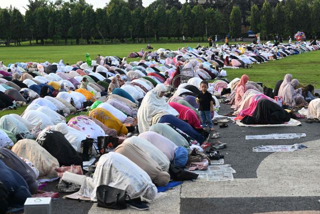 Muslim devotees offer Eid al-Fitr prayer at Bali's Bajra Sandhi monument and park in Denpasar, on Indonesia's resort island of Bali on March 20, 2026, marking the end of holy month of Ramadan. (Photo by SONNY TUMBELAKA / AFP)