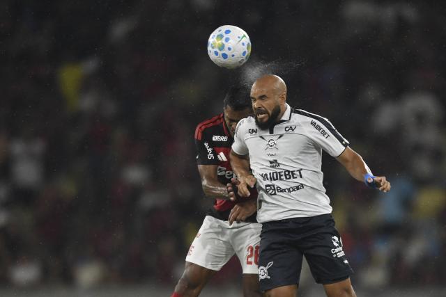 Flamengo's defender #26 Alex Sandro (L) and Remo's midfielder #28 Ze Welison jump to head the ball during the Brasileirao Serie A football match between Flamengo and Remo at the Maracana Stadium in Rio de Janeiro, Brazil, on March 19, 2026. (Photo by Daniel RAMALHO / AFP)