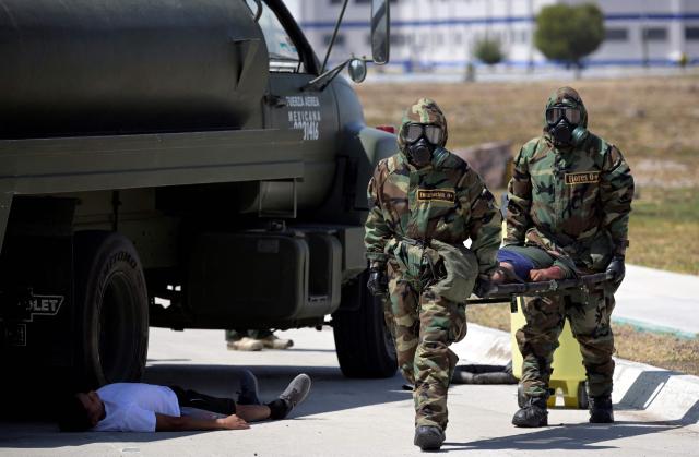 Mexican Army soldiers in radiation-protection suits take part in a simulated radioactive-accident exercise as part of ‘Exercise Ollamani’ at the Santa Lucia Military Base in the municipality of Zumpango, State of Mexico, Mexico, on March 19, 2026. "Exercise Ollamani" is organized by various institutions—including the Mexican Army, the National Guard, and the Attorney General's Office—and serves as an anti-terrorism drill designed to safeguard the 2026 World Cup. (Photo by Alfredo ESTRELLA / AFP)