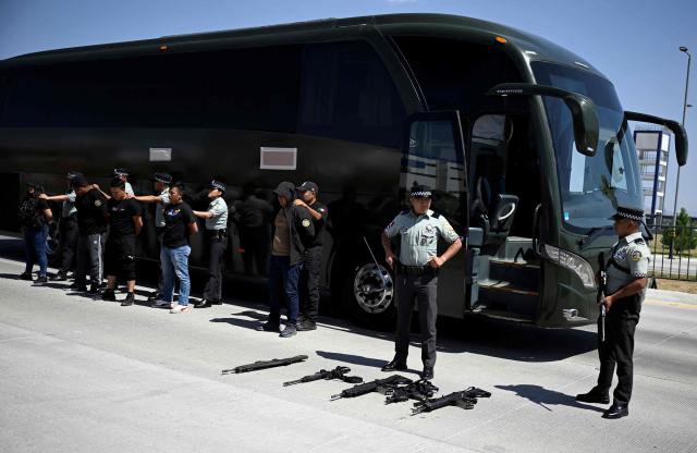 Agents of the National Guard take part in a simulated bus-robbery exercise as part of ‘Exercise Ollamani’ at the Santa Lucia Military Base in the municipality of Zumpango, State of Mexico, Mexico, on March 19, 2026. "Exercise Ollamani" is organized by various institutions—including the Mexican Army, the National Guard, and the Attorney General's Office—and serves as an anti-terrorism drill designed to safeguard the 2026 World Cup. (Photo by Alfredo ESTRELLA / AFP)