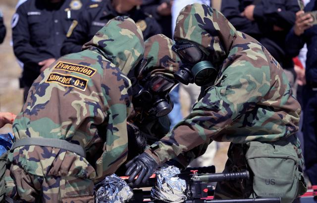 Mexican Army soldiers in radiation-protection suits take part in a simulated radioactive-accident exercise as part of ‘Exercise Ollamani’ at the Santa Lucia Military Base in the municipality of Zumpango, State of Mexico, Mexico, on March 19, 2026. "Exercise Ollamani" is organized by various institutions—including the Mexican Army, the National Guard, and the Attorney General's Office—and serves as an anti-terrorism drill designed to safeguard the 2026 World Cup. (Photo by Alfredo ESTRELLA / AFP)