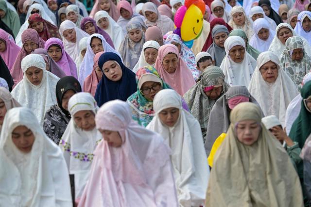 Muslim devotees offer Eid al-Fitr morning prayer along a road in Surabaya on March 20, 2026, marking the end of holy month of Ramadan. (Photo by JUNI KRISWANTO / AFP)