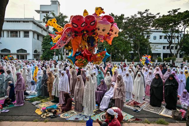 Muslim devotees offer Eid al-Fitr morning prayer along a road in Surabaya on March 20, 2026, marking the end of holy month of Ramadan. (Photo by JUNI KRISWANTO / AFP)