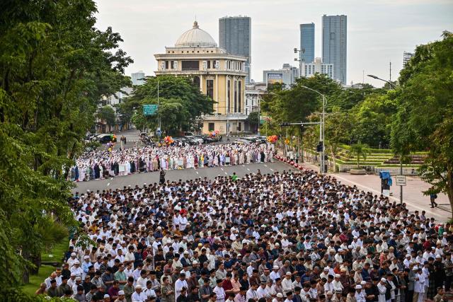 Muslim devotees offer Eid al-Fitr morning prayer along a road in Surabaya on March 20, 2026, marking the end of holy month of Ramadan. (Photo by JUNI KRISWANTO / AFP)