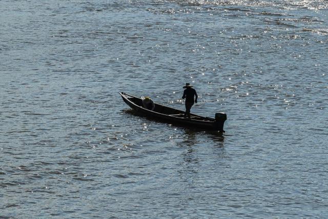 People use boats to cross the border near the San Miguel International Bridge, at the frontier between Colombia and Ecuador, which remains closed due to the commercial tax dispute between the two countries, on March 19, 2026. Ecuador escalated a month-old trade war with Colombia on February 26, 2026, hiking tariffs on imports from its neighbor to 50 percent over Bogota's alleged failure to combat organized crime along their shared border. (Photo by Luis ACOSTA / AFP)