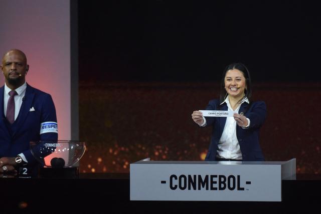 Conmebol Competition Manager Luciana Antunez shows the slip of Paraguay's Cerro Porteno next to former Brazilian footballer Felipe Melo during the Copa Libertadores group-stage draw in Luque, Asuncion, on March 19, 2026. (Photo by DANIEL DUARTE / AFP)
