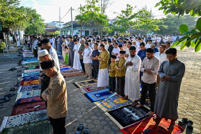 Muslim devotees take part in a morning prayer celebrating Eid al-Fitr, which marks the end of the holy month of Ramadan, in the compounds of the Muhammadiyah University in Banda Aceh on March 20, 2026. (Photo by CHAIDEER MAHYUDDIN / AFP/Chaideer MAHYUDDIN / AFP)