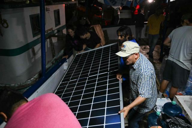 Activists hold a solar panel inside a boat, nicknamed ‘Grandma 2’, as they prepare for its departure to deliver humanitarian assistance to Cuba, as part of the Convoy to Cuba organized by left?wing activists from various countries in the Americas and Europe, in Puerto Progreso, Yucatбn state, Mexico, on March 19, 2026. The first shipment of international aid for crisis-hit Cuba arrived in the country from Europe on March 18, 2026 in the shape of five tons of medical supplies. (Photo by YURI CORTEZ / AFP)