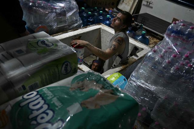 TOPSHOT - Activists organize bags of aid inside a boat, nicknamed ‘Grandma 2’, as they prepare for its departure to deliver humanitarian assistance to Cuba, as part of the Convoy to Cuba organized by left?wing activists from various countries in the Americas and Europe, in Puerto Progreso, Yucatбn state, Mexico, on March 19, 2026. The first shipment of international aid for crisis-hit Cuba arrived in the country from Europe on March 18, 2026 in the shape of five tons of medical supplies. (Photo by YURI CORTEZ / AFP)