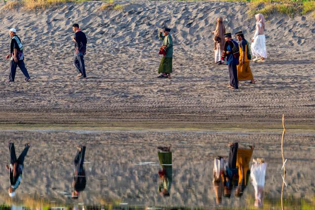 Muslim devotees from the Muhammadiyah organization arrive to perform the Eid al-Fitr prayer, marking the end of the holy month of Ramadan, at Parangkusumo Beach in Bantul, Yogyakarta on March 20, 2026. (Photo by DEVI RAHMAN / AFP)