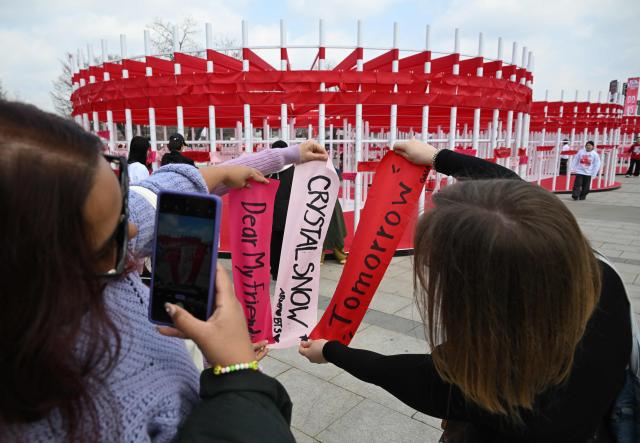 BTS fans take a picture of banners inscribed with their love songs at a fan zone promoting the new album of K-pop boy band BTS at a riverside park in Seoul on March 20, 2026. K-pop megastars BTS release the new album "ARIRANG" on March 20, billed as reflecting the maturing boy band's Korean roots and identity, as buzz builds ahead of their open-air comeback concert in the heart of Seoul. (Photo by Jung Yeon-je / AFP)