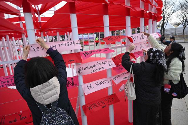 BTS fans hang banners inscribed with their love songs at a fan zone promoting the new album of K-pop boy band BTS at a riverside park in Seoul on March 20, 2026. K-pop megastars BTS release the new album "ARIRANG" on March 20, billed as reflecting the maturing boy band's Korean roots and identity, as buzz builds ahead of their open-air comeback concert in the heart of Seoul. (Photo by Jung Yeon-je / AFP)