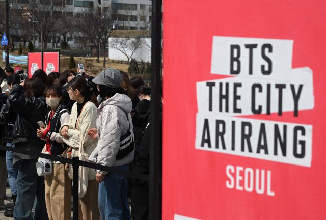 BTS fans wait in a line to enter a fan zone promoting the new album of K-pop boy band BTS at a riverside park in Seoul on March 20, 2026. K-pop megastars BTS release the new album "ARIRANG" on March 20, billed as reflecting the maturing boy band's Korean roots and identity, as buzz builds ahead of their open-air comeback concert in the heart of Seoul. (Photo by Jung Yeon-je / AFP)