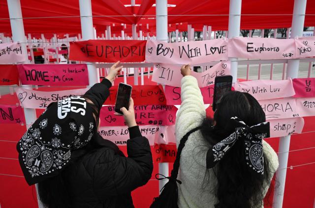BTS fans hang banners inscribed with their love songs at a fan zone promoting the new album of K-pop boy band BTS at a riverside park in Seoul on March 20, 2026. K-pop megastars BTS release the new album "ARIRANG" on March 20, billed as reflecting the maturing boy band's Korean roots and identity, as buzz builds ahead of their open-air comeback concert in the heart of Seoul. (Photo by Jung Yeon-je / AFP)
