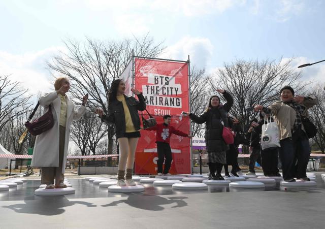 BTS fans enjoy themselves at a fan zone promoting the new album of K-pop boy band BTS at a riverside park in Seoul on March 20, 2026. K-pop megastars BTS release the new album "ARIRANG" on March 20, billed as reflecting the maturing boy band's Korean roots and identity, as buzz builds ahead of their open-air comeback concert in the heart of Seoul. (Photo by Jung Yeon-je / AFP)