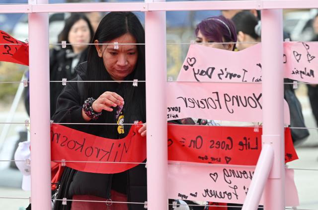 BTS fans hang banners inscribed with their love songs at a fan zone promoting the new album of K-pop boy band BTS at a riverside park in Seoul on March 20, 2026. K-pop megastars BTS release the new album "ARIRANG" on March 20, billed as reflecting the maturing boy band's Korean roots and identity, as buzz builds ahead of their open-air comeback concert in the heart of Seoul. (Photo by Jung Yeon-je / AFP)
