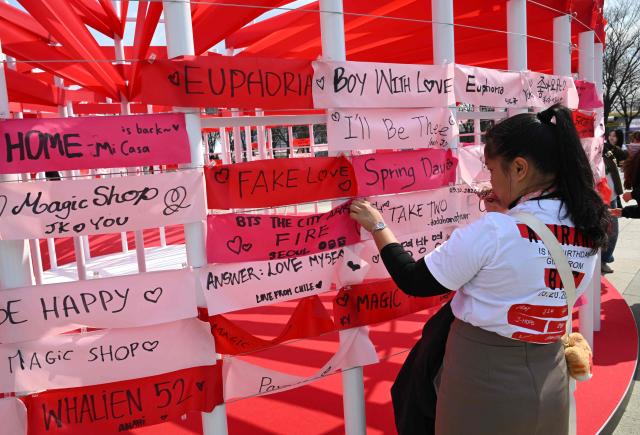 BTS fans hang banners inscribed with their love songs at a fan zone promoting the new album of K-pop boy band BTS at a riverside park in Seoul on March 20, 2026. K-pop megastars BTS release the new album "ARIRANG" on March 20, billed as reflecting the maturing boy band's Korean roots and identity, as buzz builds ahead of their open-air comeback concert in the heart of Seoul. (Photo by Jung Yeon-je / AFP)