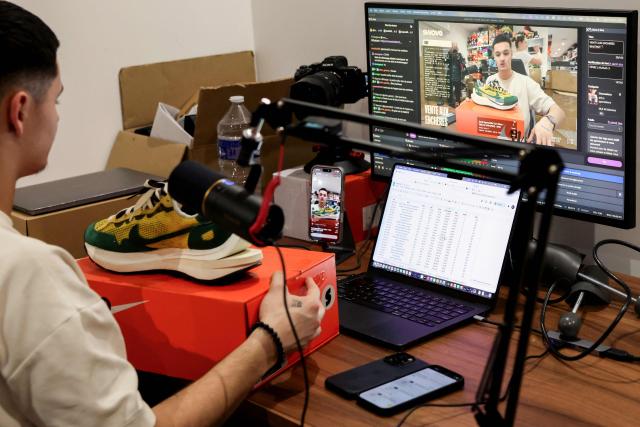 Swave founder Hugo Carvalho attends a live sneakers auction sale session on the Whatnot app platform on, in Paris March 12, 2026. Teleshopping isn’t dead; it’s just moved to mobile: combining live video with instant purchasing, ‘live shopping’ is revolutionising online retail, prompting tech giants, brands and small shops alike to get on board. ‘Starting price: one euro... 20 seconds to bid. 3, 2, 1, go!’ Sitting in front of his multiple screens, Hugo Carvalho, founder of the Parisian shop Swave, which specialises in collectable trainers, is shouting himself hoarse live on the Whatnot app. (Photo by ALAIN JOCARD / AFP)