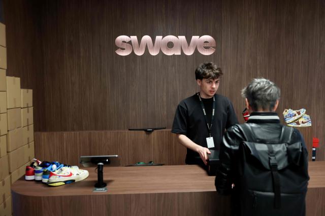 A client buys sneakers purchased during a live sneakers auction sale session on the Whatnot app platform at the Swave store in Paris March 12, 2026. Teleshopping isn’t dead; it’s just moved to mobile: combining live video with instant purchasing, ‘live shopping’ is revolutionising online retail, prompting tech giants, brands and small shops alike to get on board. ‘Starting price: one euro... 20 seconds to bid. 3, 2, 1, go!’ Sitting in front of his multiple screens, Hugo Carvalho, founder of the Parisian shop Swave, which specialises in collectable trainers, is shouting himself hoarse live on the Whatnot app. (Photo by ALAIN JOCARD / AFP)