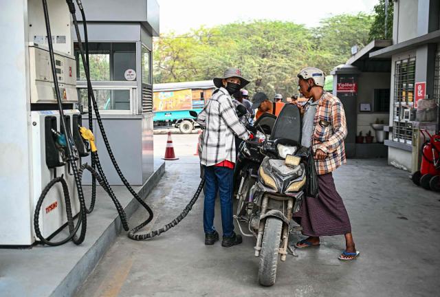 An employee refuels a vehicle at a petrol station amid rising prices in Mandalay on March 20, 2026. (Photo by Sai Aung MAIN / AFP)