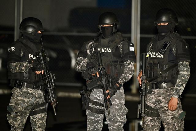 Ecuador’s police officers stand guard while Ecuadorian drug trafficker Бngel Aguilar (out of frame), alias ‘Lobo Menor’, arrives at the Aeropolicial facilities at the airport in Guayaquil on March 19, 2026. Colombian immigration authorities said on March 18, 2026, they had arrested an Ecuadoran drug trafficker linked to the 2023 murder of a popular candidate just before Ecuador's presidential election. (Photo by Marcos PIN / AFP)