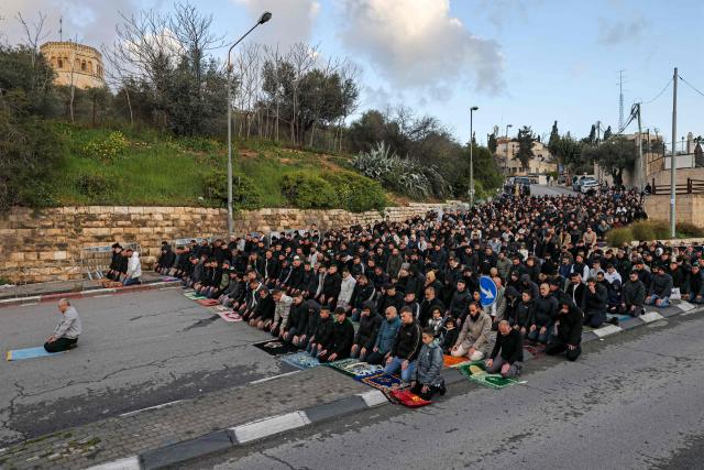 TOPSHOT - Muslim worshippers gather outside the Jerusalem old city walls on March 20, 2026 to attend attend the early morning prayers for Eid al-Fitr, marking the end of the holy month of Ramadan. Holy sites such as the Aqsa mosque compound in Jerusalem's old city have remained closed for security reasons since the outbreak of the Middle East war on February 28, when Israel and the US launched strikes on Iran. (Photo by AHMAD GHARABLI / AFP)