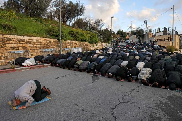Muslim worshippers gather outside the Jerusalem old city walls on March 20, 2026 to attend attend the early morning prayers for Eid al-Fitr, marking the end of the holy month of Ramadan. Holy sites such as the Aqsa mosque compound in Jerusalem's old city have remained closed for security reasons since the outbreak of the Middle East war on February 28, when Israel and the US launched strikes on Iran. (Photo by AHMAD GHARABLI / AFP)