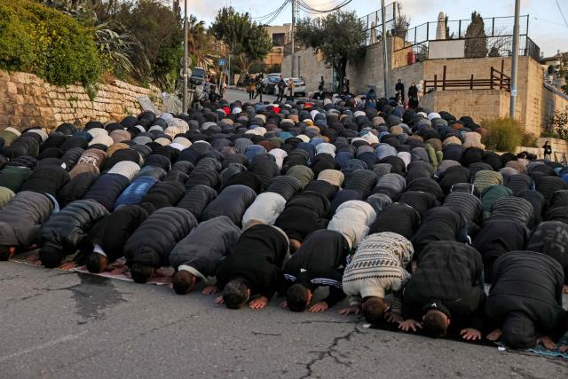 Muslim worshippers gather outside the Jerusalem old city walls on March 20, 2026 to attend attend the early morning prayers for Eid al-Fitr, marking the end of the holy month of Ramadan. Holy sites such as the Aqsa mosque compound in Jerusalem's old city have remained closed for security reasons since the outbreak of the Middle East war on February 28, when Israel and the US launched strikes on Iran. (Photo by AHMAD GHARABLI / AFP)