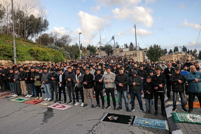 TOPSHOT - Muslim worshippers gather outside the Jerusalem old city walls on March 20, 2026 to attend attend the early morning prayers for Eid al-Fitr, marking the end of the holy month of Ramadan. Holy sites such as the Aqsa mosque compound in Jerusalem's old city have remained closed for security reasons since the outbreak of the Middle East war on February 28, when Israel and the US launched strikes on Iran. (Photo by AHMAD GHARABLI / AFP)