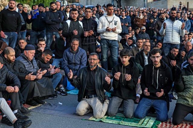 Muslim worshippers gather outside the Jerusalem old city walls on March 20, 2026 to attend attend the early morning prayers for Eid al-Fitr, marking the end of the holy month of Ramadan. Holy sites such as the Aqsa mosque compound in Jerusalem's old city have remained closed for security reasons since the outbreak of the Middle East war on February 28, when Israel and the US launched strikes on Iran. (Photo by AHMAD GHARABLI / AFP)