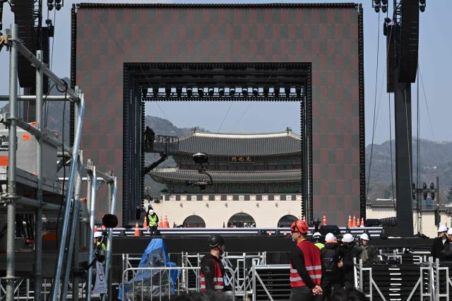 Workers set up the stage for the comeback concert of K-pop boy group BTS at Gwanghwamun Square in Seoul on March 20, 2026. K-pop megastars BTS released a new album on March 20, billed as reflecting the maturing boy band's Korean roots and identity, as buzz built ahead of their open-air comeback concert in the heart of Seoul. (Photo by Jung Yeon-je / AFP)