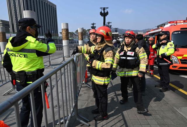 Firefighters check safety at the venue for the comeback concert of K-pop boy group BTS at Gwanghwamun Square in Seoul on March 20, 2026. K-pop megastars BTS released a new album on March 20, billed as reflecting the maturing boy band's Korean roots and identity, as buzz built ahead of their open-air comeback concert in the heart of Seoul. (Photo by Jung Yeon-je / AFP)