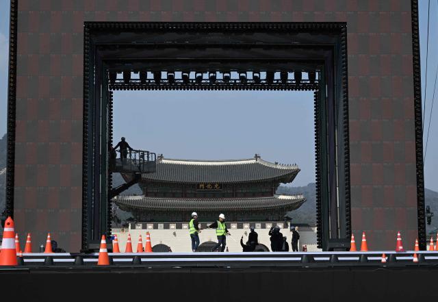 Workers set up the stage for the comeback concert of K-pop boy group BTS at Gwanghwamun Square in Seoul on March 20, 2026. K-pop megastars BTS released a new album on March 20, billed as reflecting the maturing boy band's Korean roots and identity, as buzz built ahead of their open-air comeback concert in the heart of Seoul. (Photo by Jung Yeon-je / AFP)