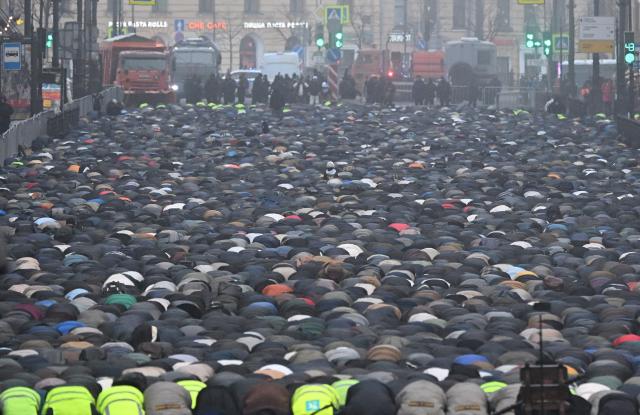 Muslim worshippers perform the early morning prayers for Eid al-Fitr, marking the end of the holy month of Ramadan, on a street in Saint Petersburg on March 20, 2026. (Photo by Olga MALTSEVA / AFP)