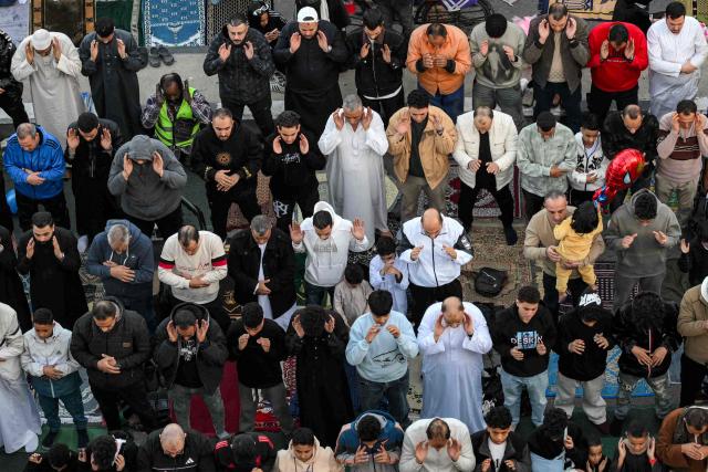 Muslim worshippers gather for the early morning prayers for Eild a-Fitr, marking the end of the holy month of Ramadan, along a main street outside the Siddiq Mosque in eastern Cairo's Heliopolis district on March 20, 2026. (Photo by Ahmed HASAN / AFP)