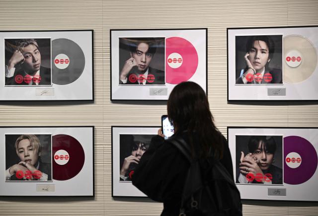 A visitor takes a picture of BTS' new album CDs displayed at a BTS pop-up store at Shinsegae Department Store's The Heritage in Seoul on March 20, 2026. K-pop megastars BTS released a new album on March 20, billed as reflecting the maturing boy band's Korean roots and identity, as buzz built ahead of their open-air comeback concert in the heart of Seoul. (Photo by Jung Yeon-je / AFP)