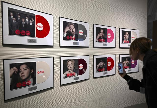 A visitor takes a picture of BTS' new album CDs displayed at a BTS pop-up store at Shinsegae Department Store's The Heritage in Seoul on March 20, 2026. K-pop megastars BTS released a new album on March 20, billed as reflecting the maturing boy band's Korean roots and identity, as buzz built ahead of their open-air comeback concert in the heart of Seoul. (Photo by Jung Yeon-je / AFP)