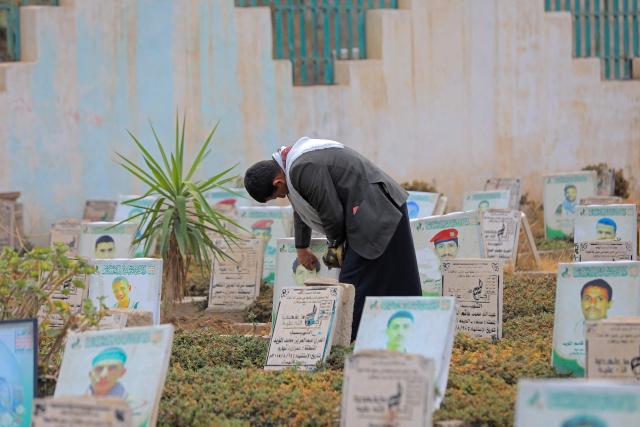 A Yemeni visits a cemetery to pray over the grave of relatives after the morning Eid al-Fitr prayers, which marks the end of the holy fasting month of Ramadan, in the capital Sanaa on March 20, 2026. (Photo by Mohammed HUWAIS / AFP)