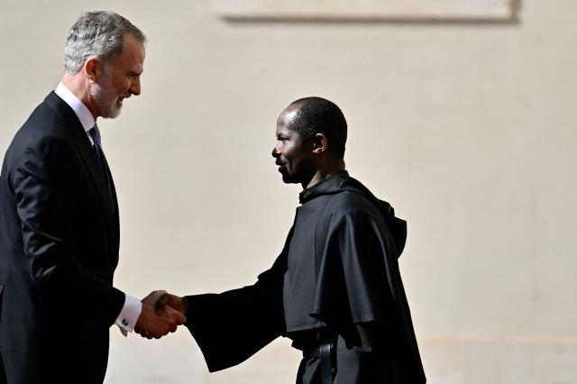 King Felipe VI of Spain is welcomed by the vice regent of Pontifical Household, Augustinian Father Edward Daniang Daleng, as he arrives for a private audience with Pope Leo XiV on March 20, 2026 at San Damaso courtyard in The Vatican. (Photo by Filippo MONTEFORTE / AFP)