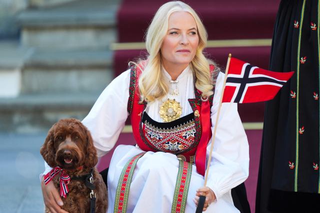 (FILES) Crown Princess Mette-Marit of Norway and the family dog greet the children's parade during the May 17 celebrations at the Royal residence, Skaugum, west of the Norwegian capital Oslo, on May 17, 2024. Norway's Crown Princess Mette-Marit said she was "manipulated" by convicted US sex offender Jeffrey Epstein, in an interview broadcast on March 20, 2026 in which she sought to explain their close relationship. A commoner who married Crown Prince Haakon in 2001, Mette-Marit's name appears in new Epstein documents released by the US Department of Justice earlier in 2026. The files revealed an unexpectedly close friendship between the pair and raised questions in Norway about whether Mette-Marit can become queen. (Photo by Lise Åserud / NTB / AFP) / Norway OUT
