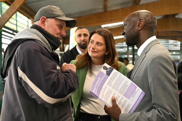 Sarcelles independent mayoral candidate Bassi Konate looks on as he campaigns with National Secretary of French green party The Ecologists Marine Tondelier (C) ahead of the second round of France's 2026 municipal elections in Sarcelles, a northern Paris suburb, on March 20, 2026. French voters head to the pools on March 22, 2026, for the second round of municipal elections. (Photo by Bertrand GUAY / AFP)