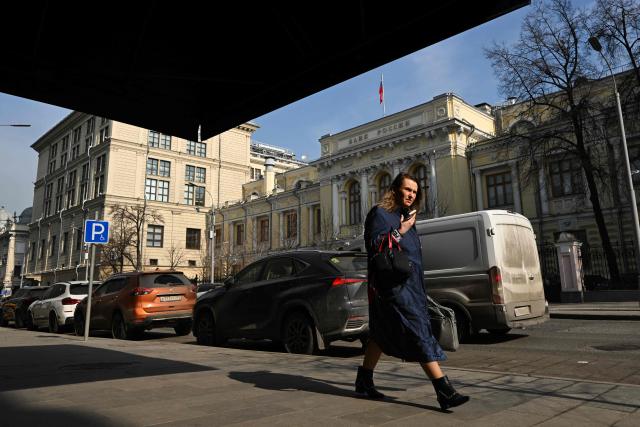 A woman walks past the Russian Central Bank headquarters in Neglinnaya street in central Moscow on March 20, 2026. Russia's central bank on March 20, 2026 cut its key interest rate to 15 percent from 15.5 percent as the economy slows under pressure from Moscow's protracted and expensive war in Ukraine and Western sanctions. (Photo by Igor IVANKO / AFP)