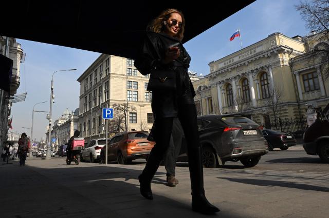 A woman walks past the Russian Central Bank headquarters in Neglinnaya street in central Moscow on March 20, 2026. Russia's central bank on March 20, 2026 cut its key interest rate to 15 percent from 15.5 percent as the economy slows under pressure from Moscow's protracted and expensive war in Ukraine and Western sanctions. (Photo by Igor IVANKO / AFP)
